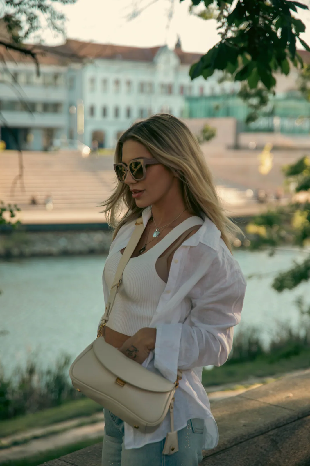 Woman posing beside an urban waterfront