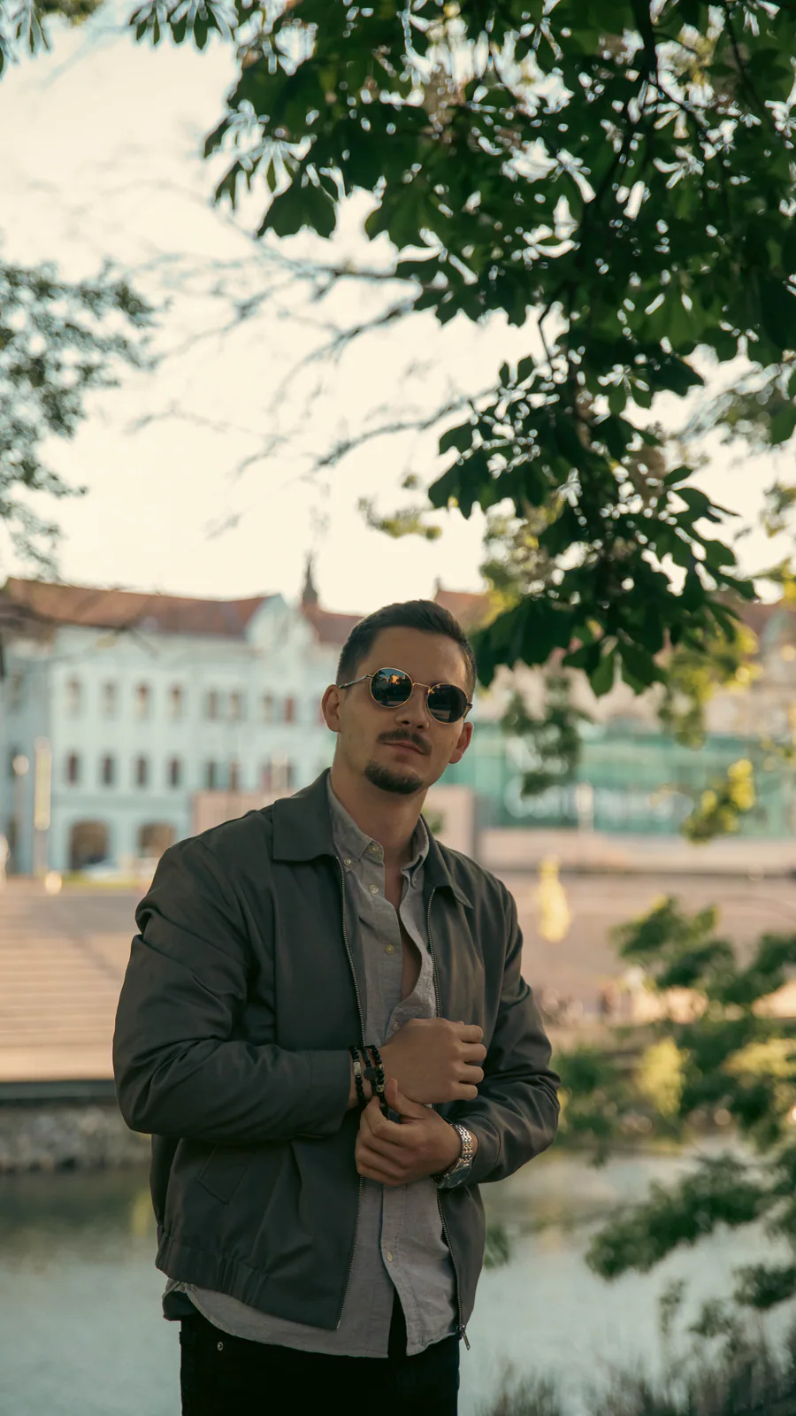 Man wearing sunglasses on a tree-lined walkway