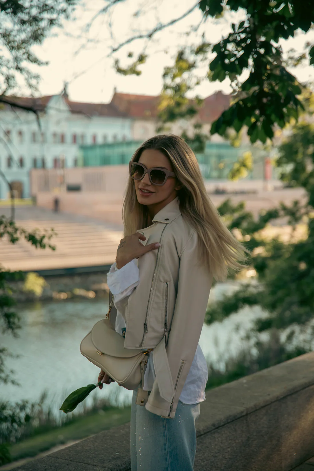 Woman wearing sunglasses on a tree-lined city walkway