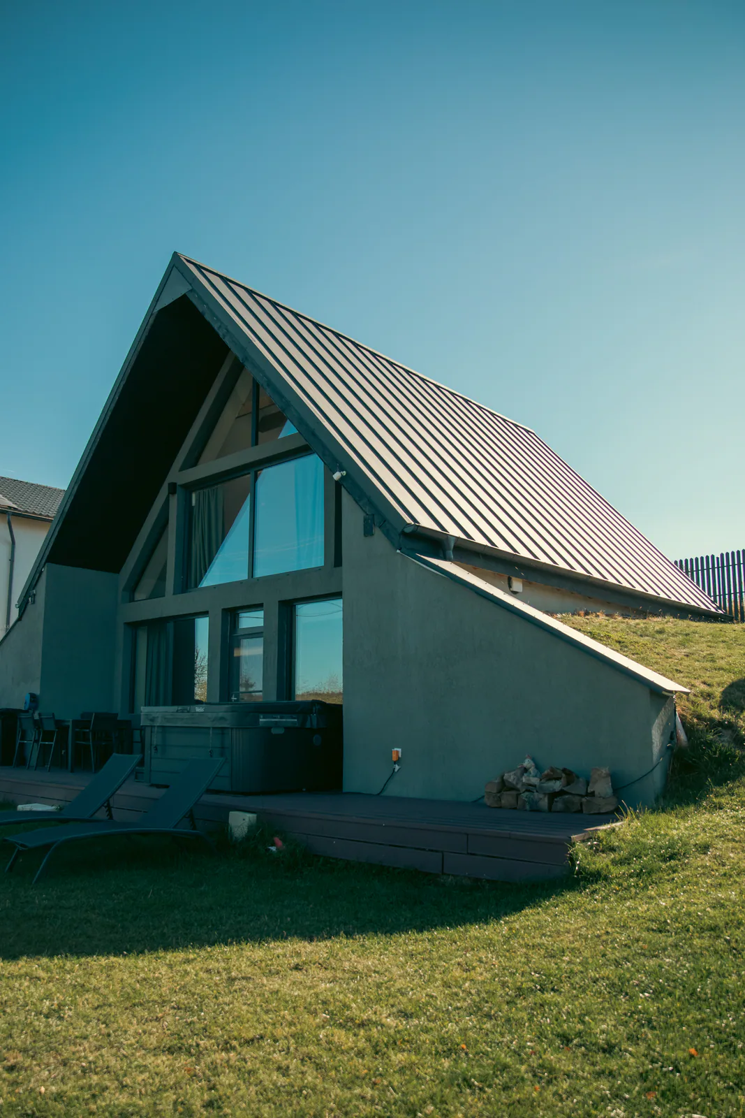 A-frame cabin with a metal roof, deck, and outdoor hot tub