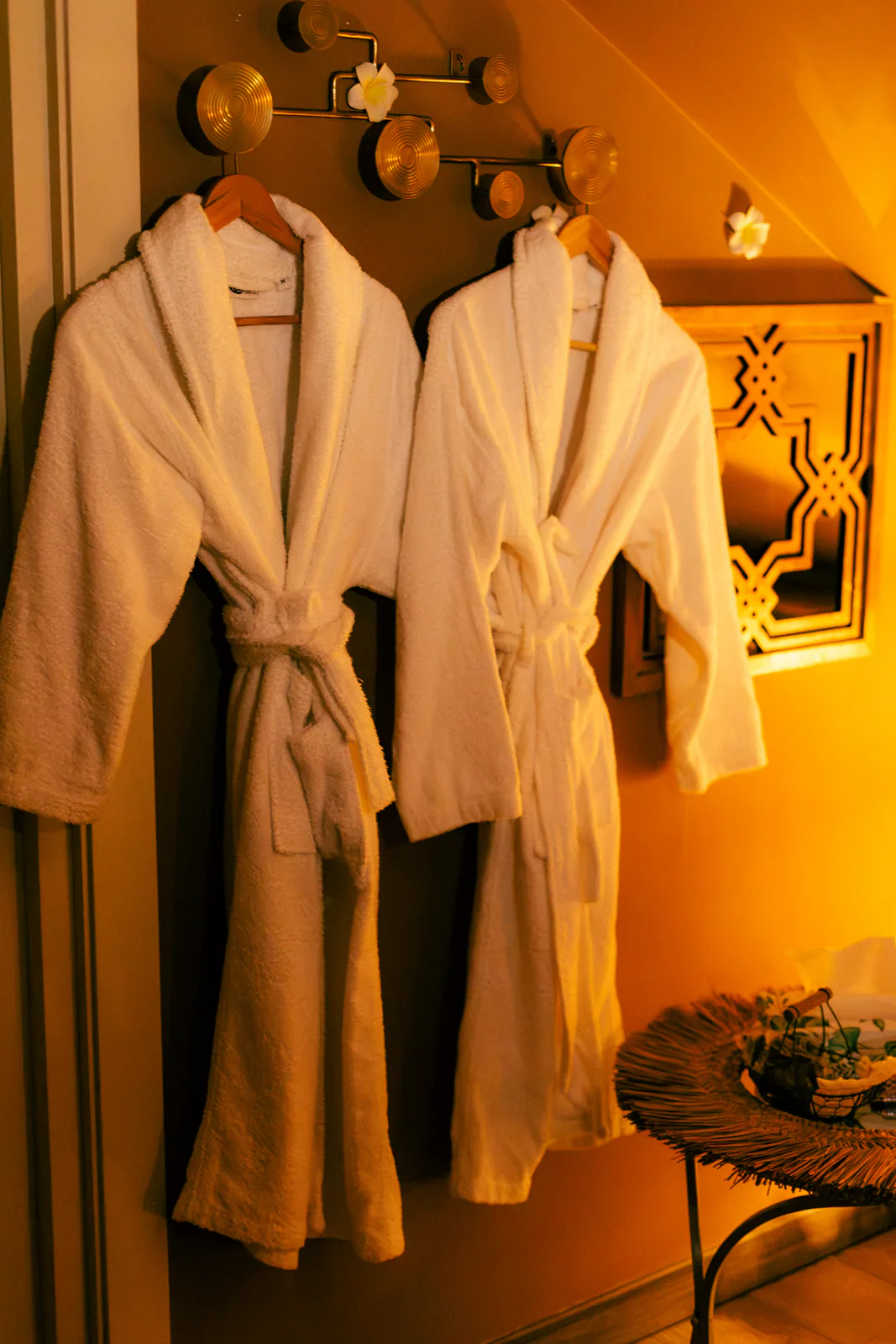 White spa robes hanging in a warmly lit treatment room
