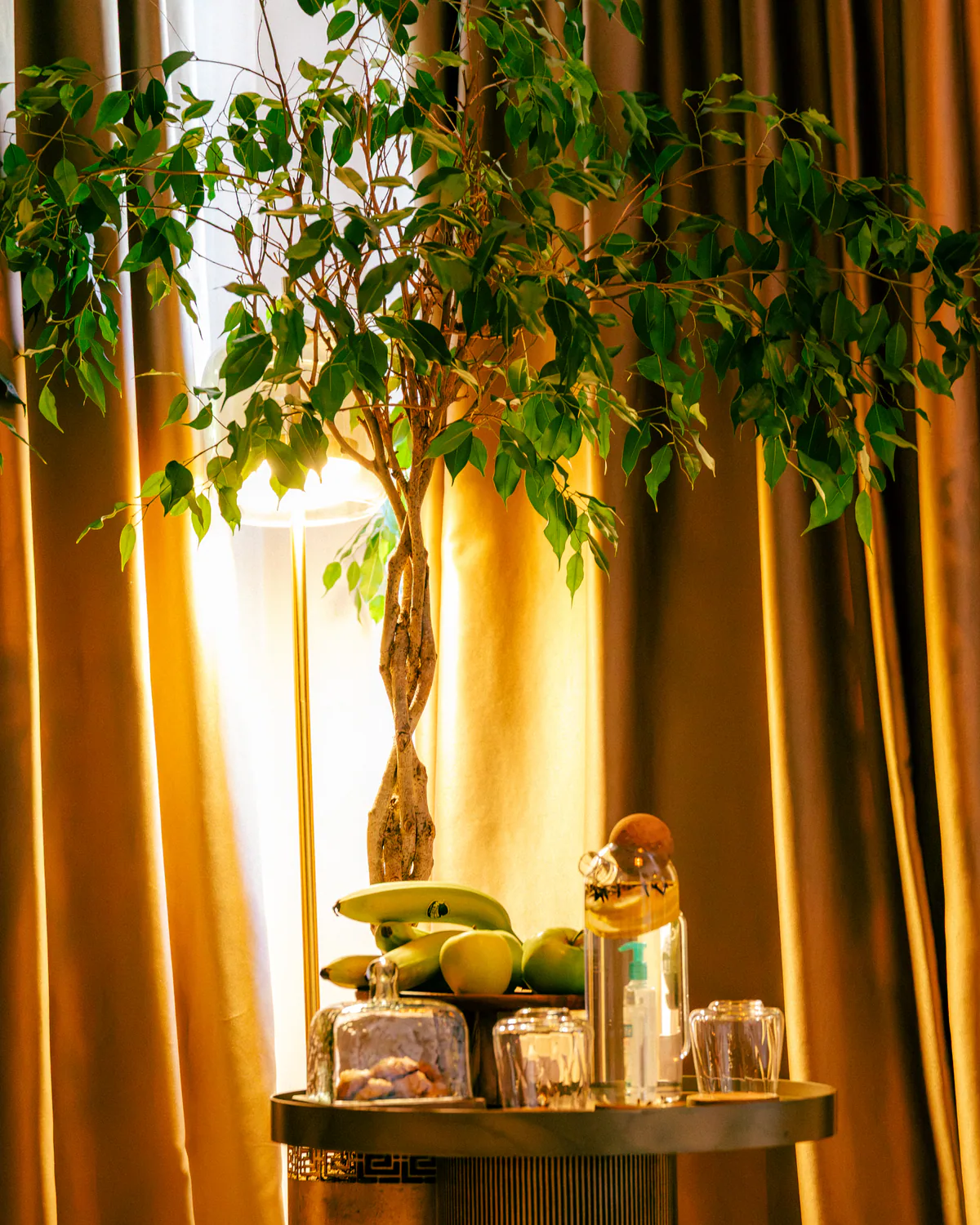Spa table with decorative objects beside softly lit curtains