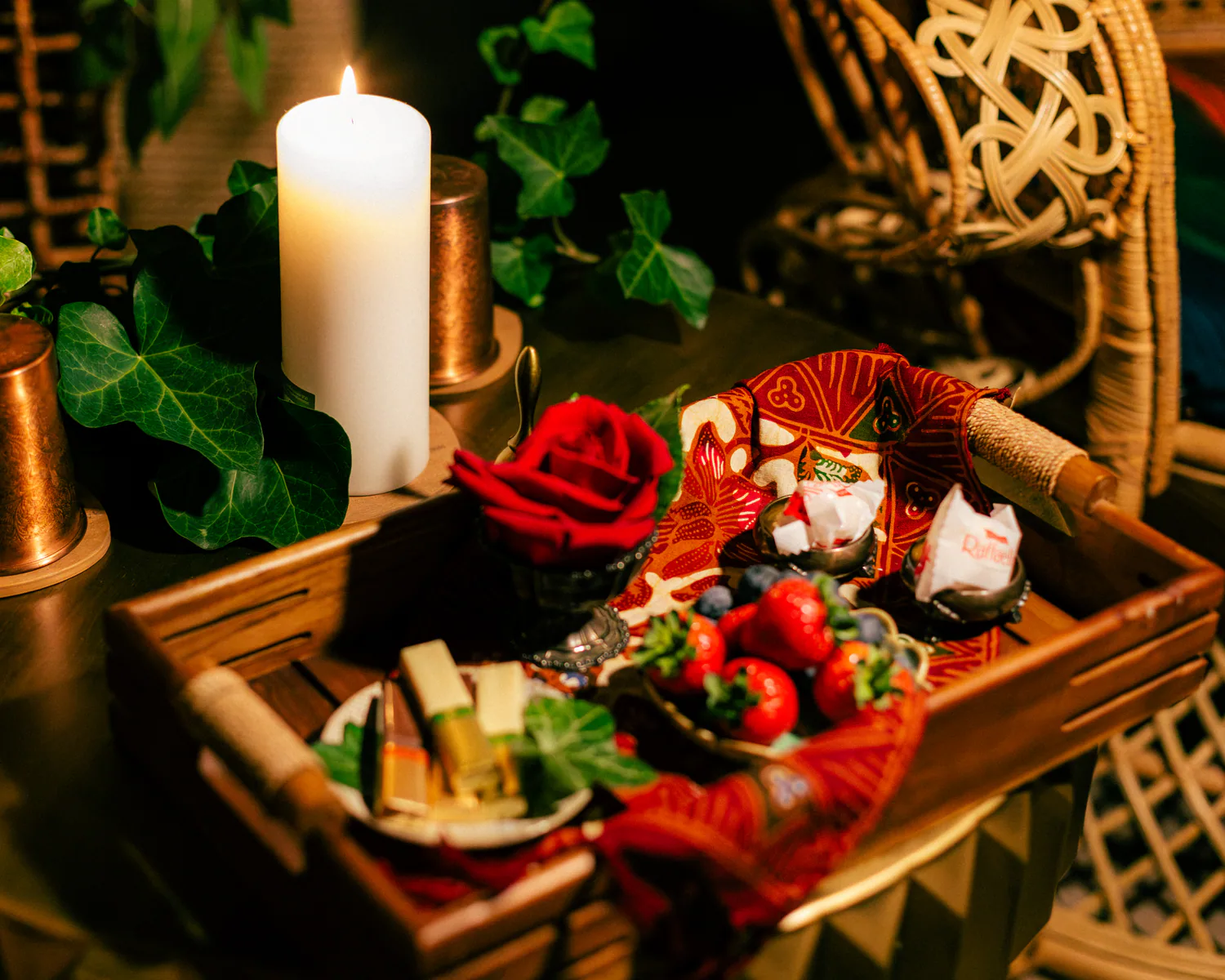 Spa tray arranged with red flowers, fruit and a candle