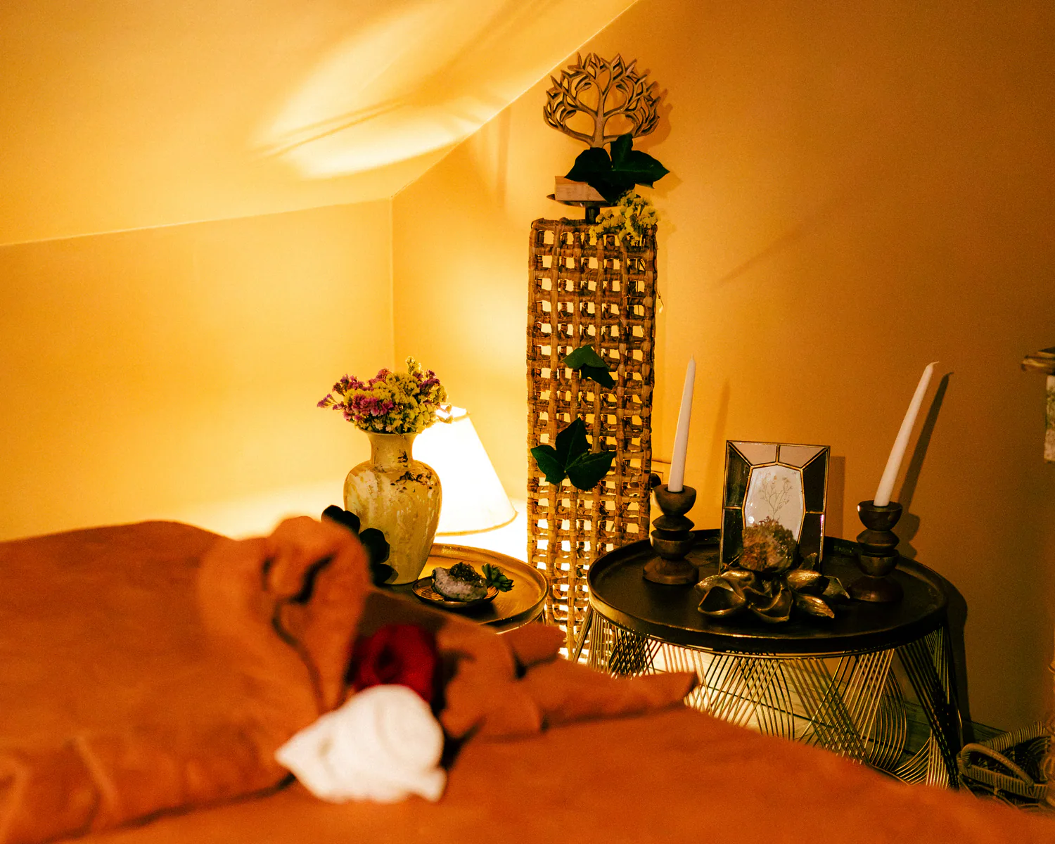 Warmly lit spa treatment room with a prepared bed