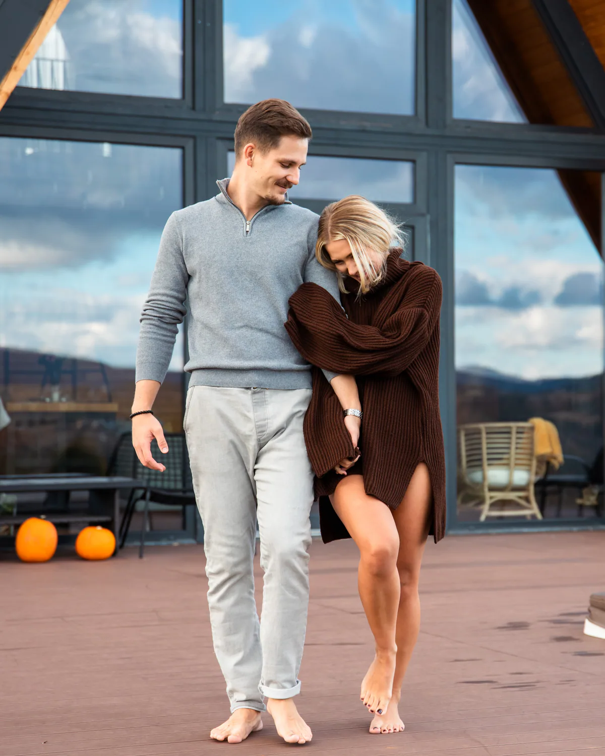 Couple walking barefoot together beside the cabin
