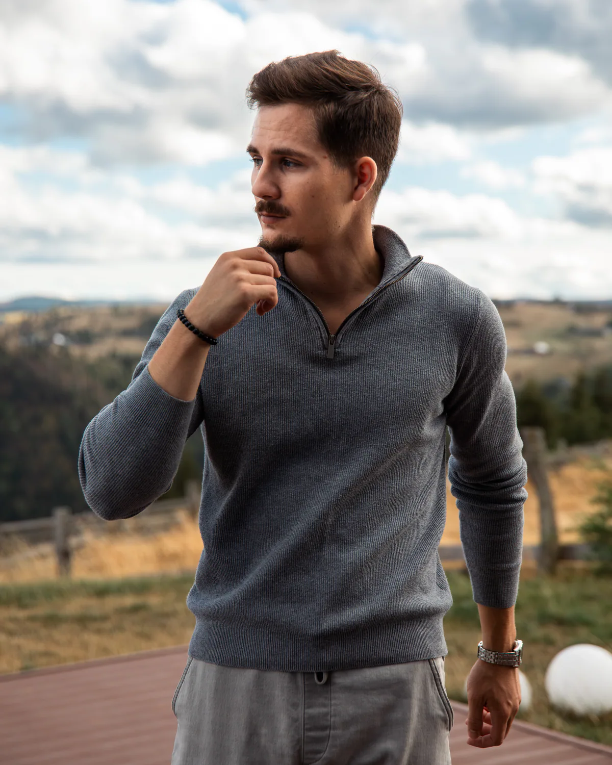 Man holding a mug on the mountain cabin terrace