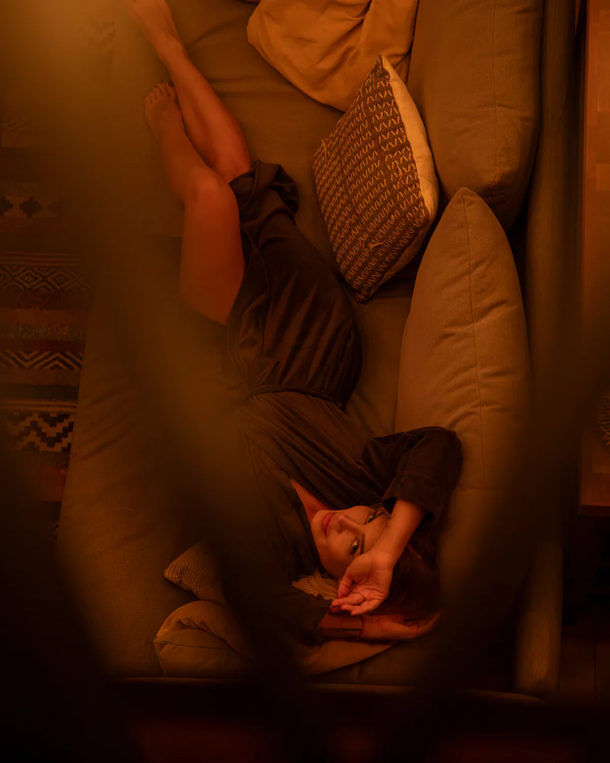 Woman reclining on a sofa in the warmly lit cabin