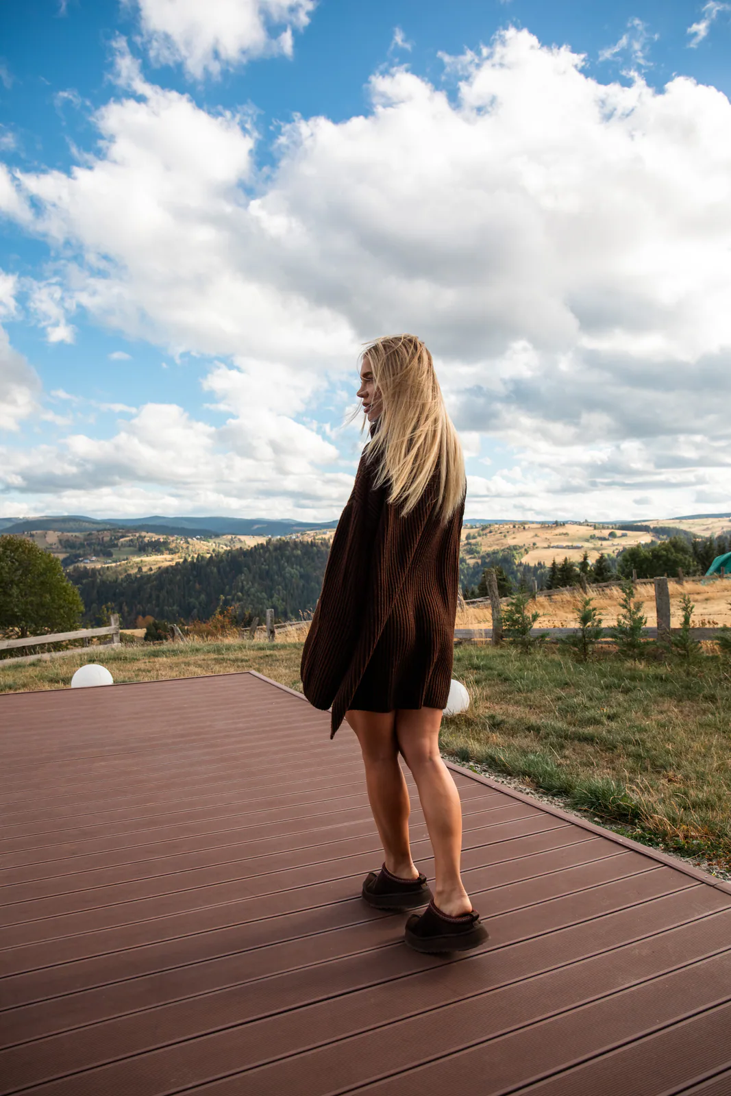 Woman walking barefoot on a terrace overlooking the mountains