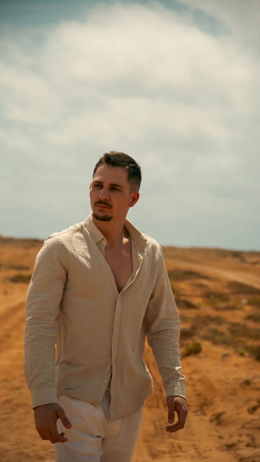 Portrait of a man in a light shirt in an open landscape