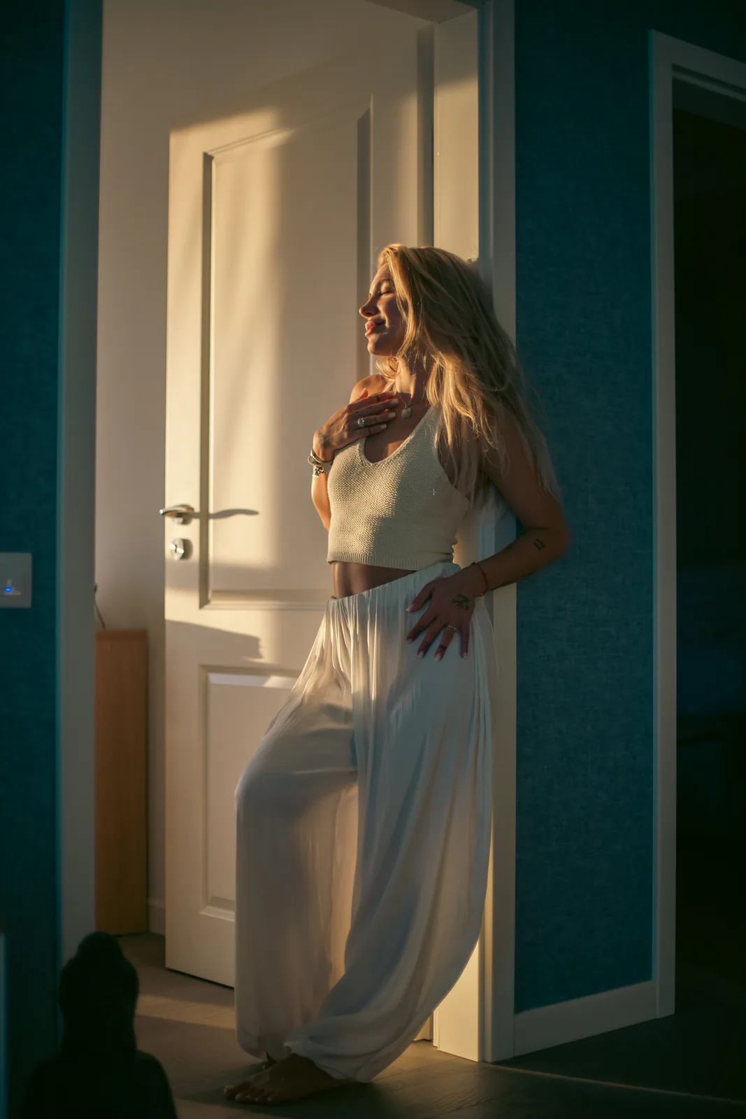 Woman posing in a sunlit doorway
