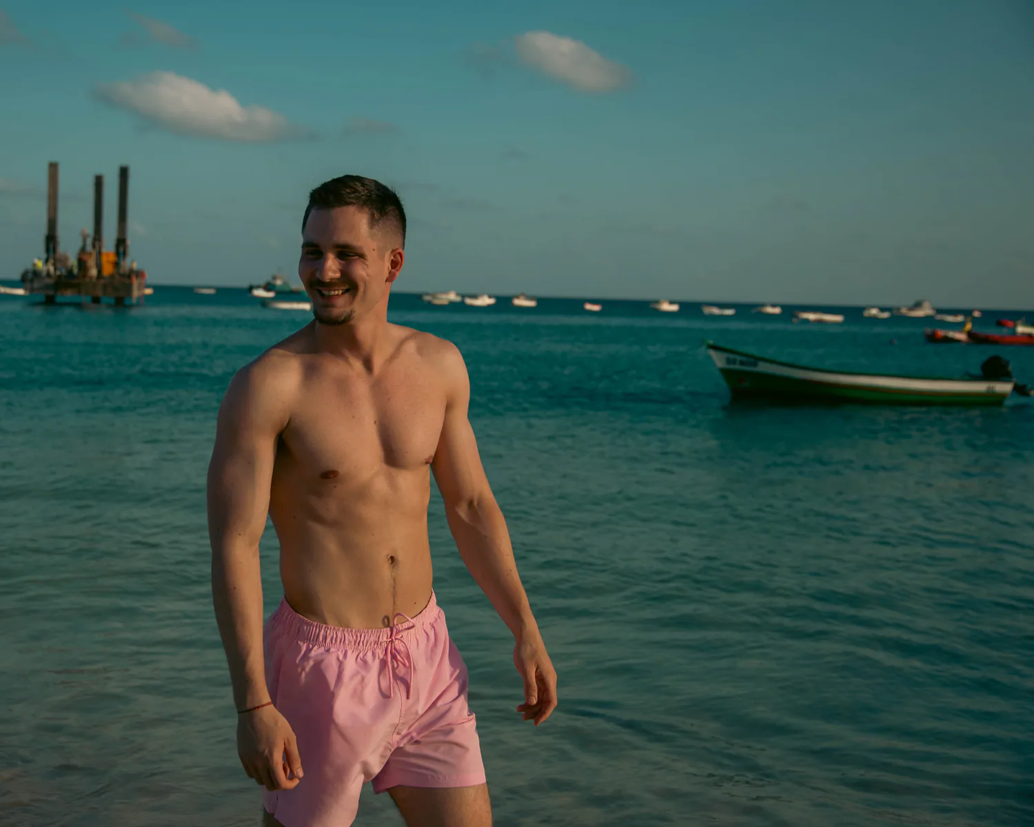 Man posing beside calm coastal water