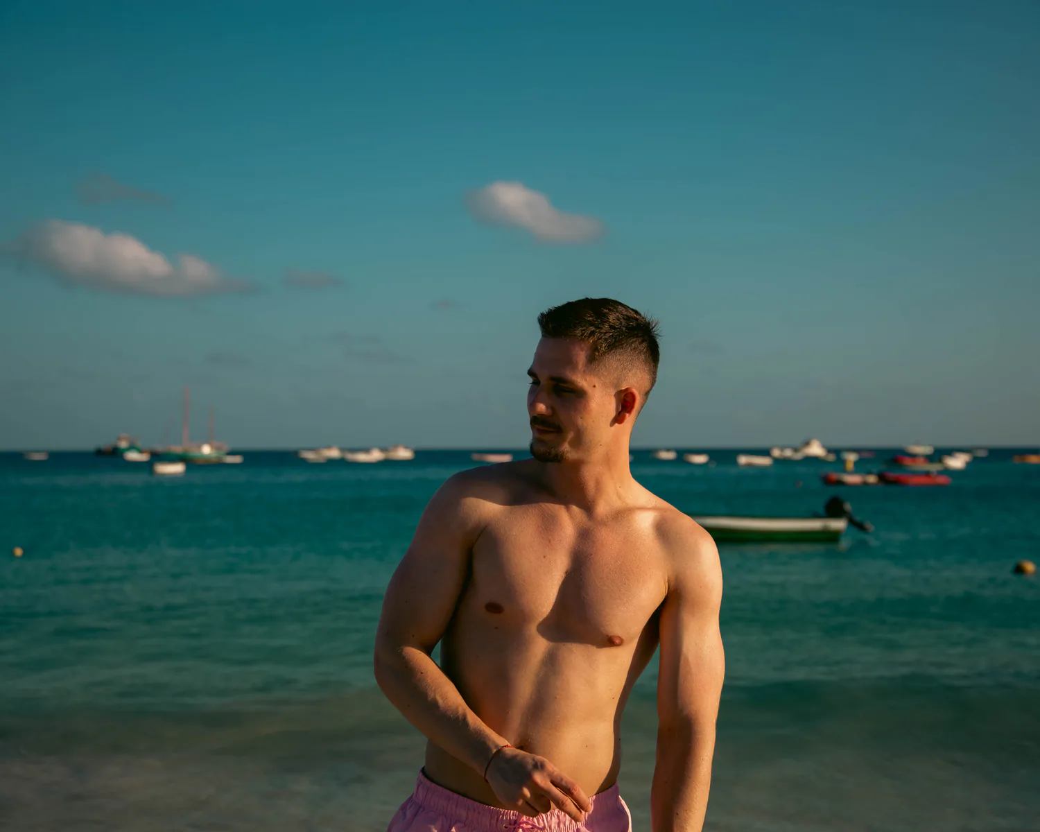 Man standing in warm light beside the sea