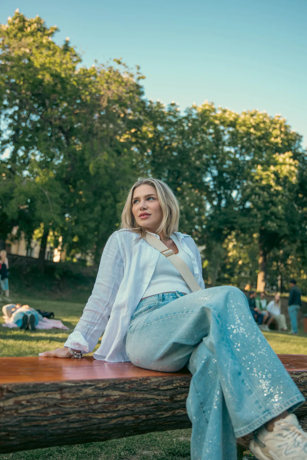 Woman in a blue outfit seated outdoors
