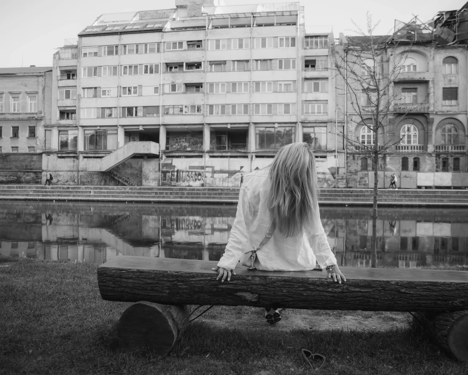 Black-and-white view of a woman seated by the water